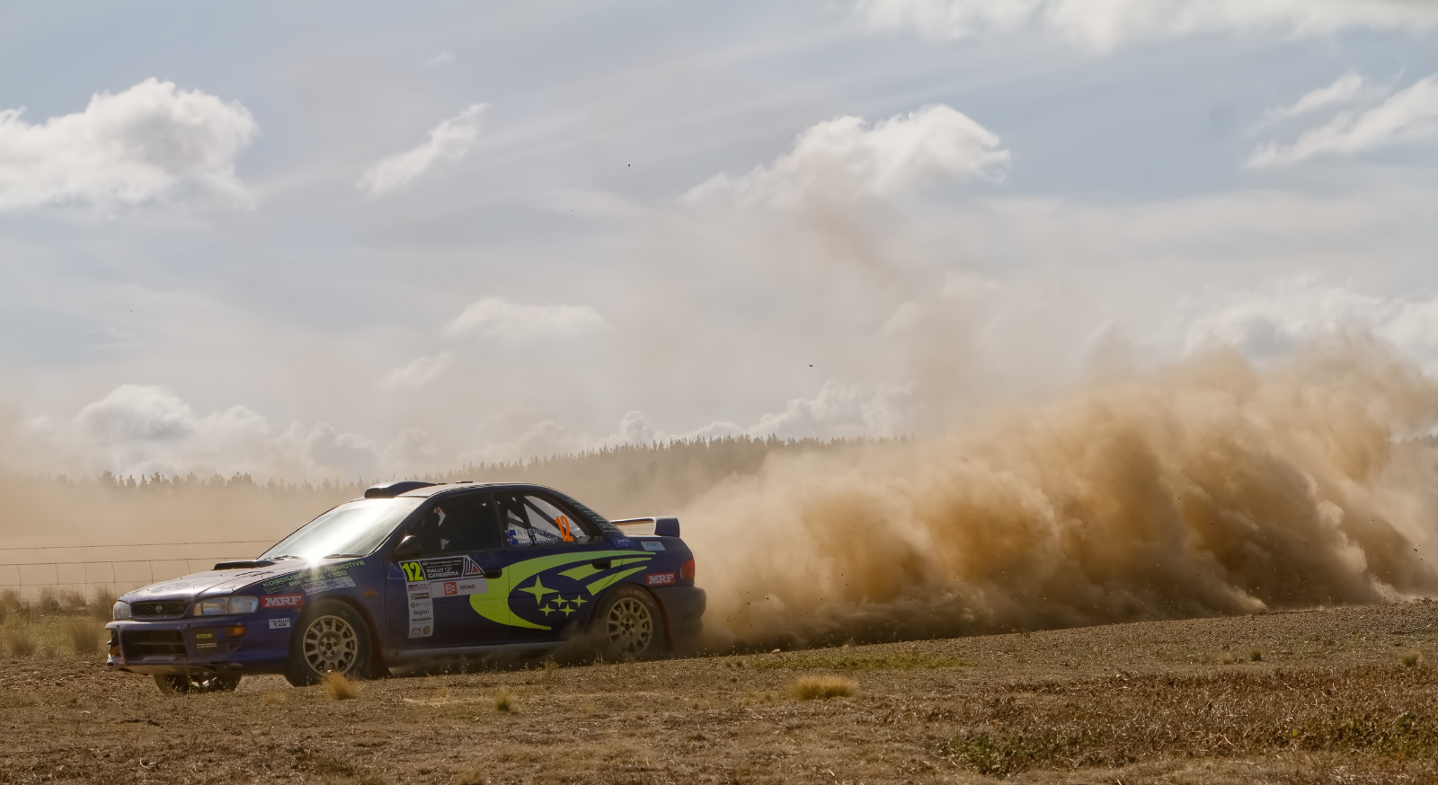 Subaru WRX rally car kicking up clouds of dust, now with reduced photographers!