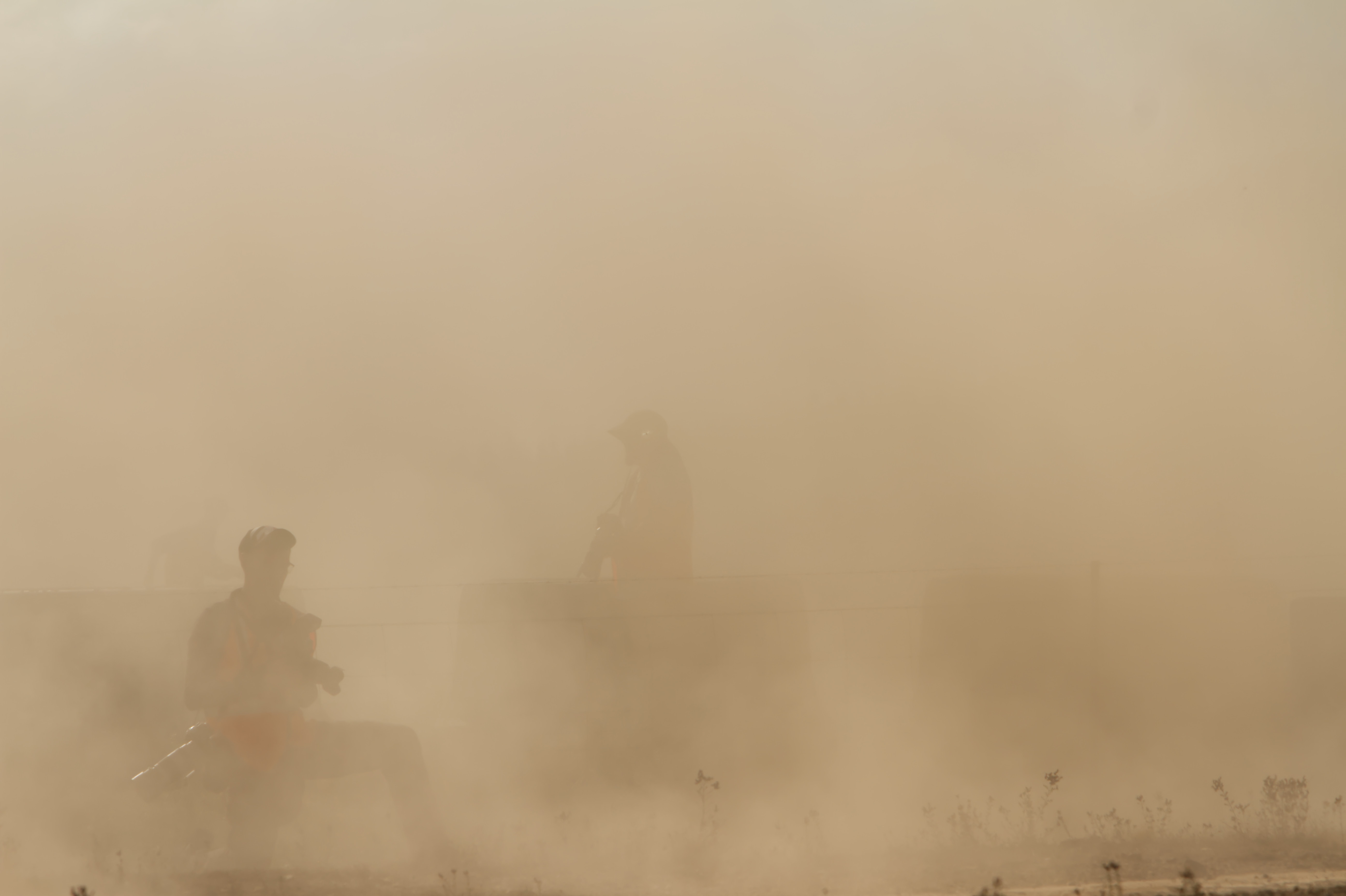 Official rally photographers in a dust cloud