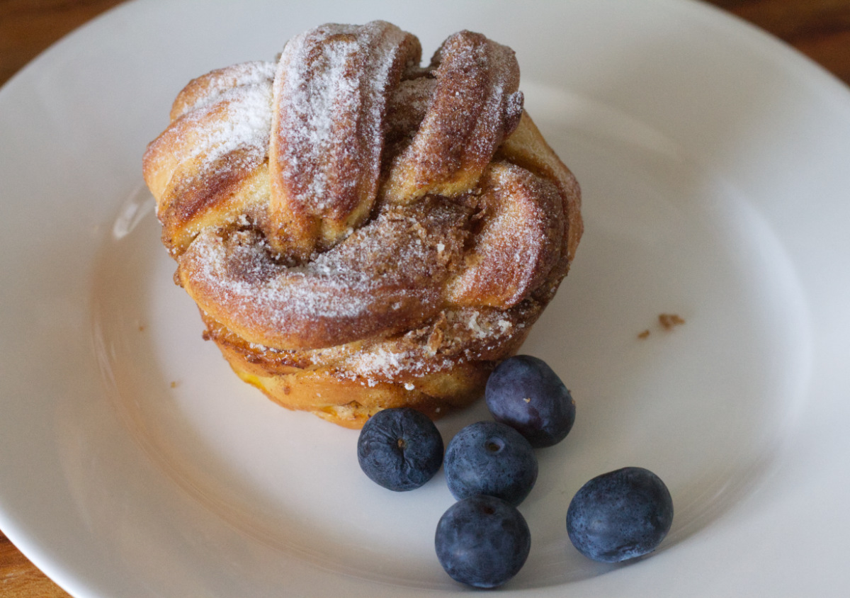 Cinnamon roll, served with blueberries.